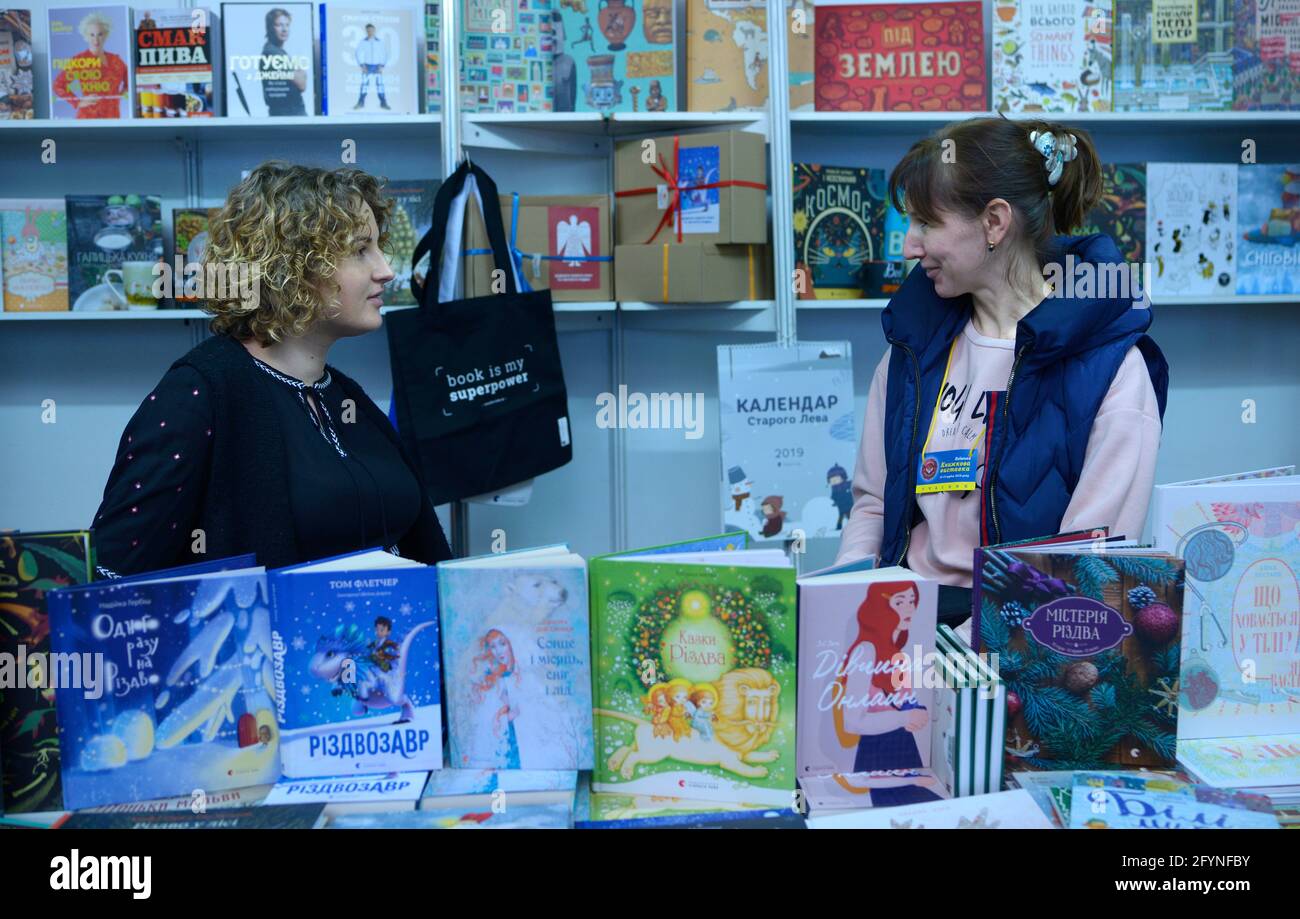 Zwei Buchhändlerinnen kommunizieren hinter einer Theke der Buchhandlung. Buchmesse Knyzhkovyi Arsenal . 24.Mai 2019. Kiew, Ukraine Stockfoto
