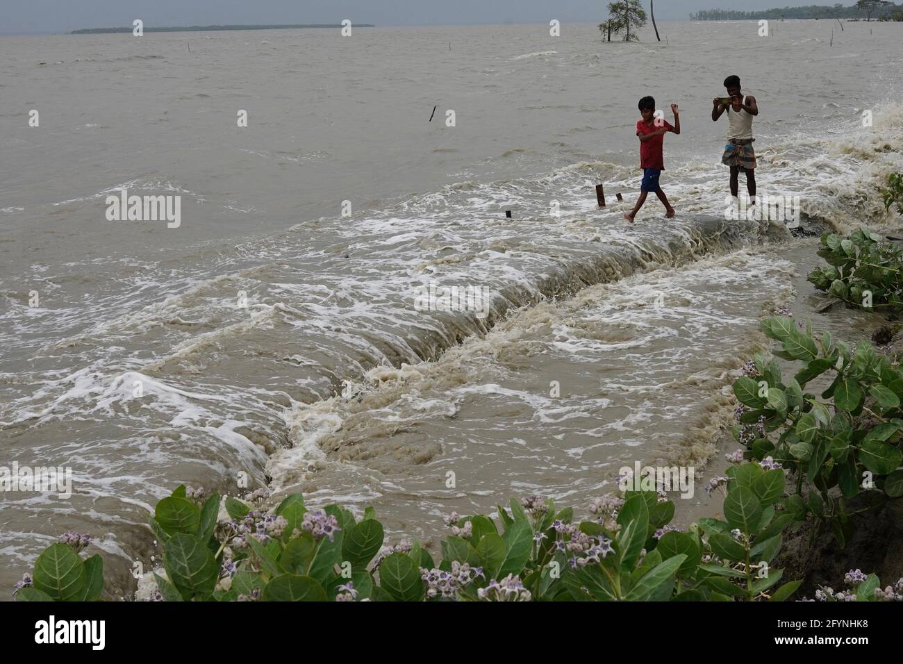 Barguna, Bangladesch. Mai 2021. Auf dem Damm stehen Menschen, während sie die Qualen des Sturms nach dem Zyklon YaaS-Effekt im Küstengebiet von Patharghata in Barguna beobachten.am Mittwoch wurden mindestens zwei Todesfälle gemeldet, als der Zyklon YaaS Stürme und Überschwemmungen in den Küstengebieten von Bangladesch auslöste. Kredit: SOPA Images Limited/Alamy Live Nachrichten Stockfoto