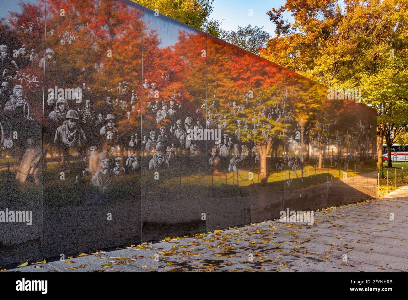 Fotografische Bilder von Soldaten und herbstlichen Bäumen spiegeln sich in der hochpolierten schwarzen Granitwand des Koreanischen Kriegsdenkmals in Washington DC wider Stockfoto