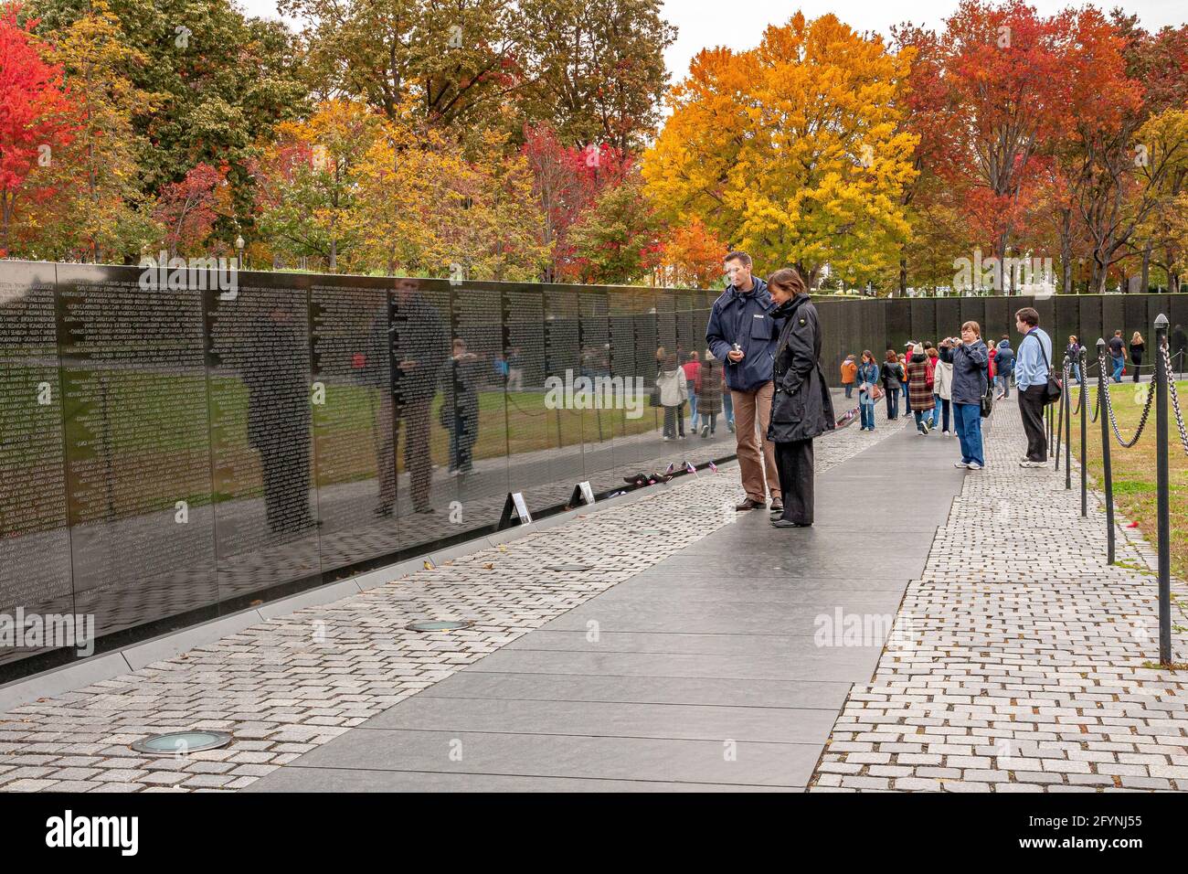 Ein Paar, das die Namen auf dem Vietnam Veterans Memorial liest, das die US-Streitkräfte ehrt, die im Vietnamkrieg in Washington DC gekämpft haben Stockfoto