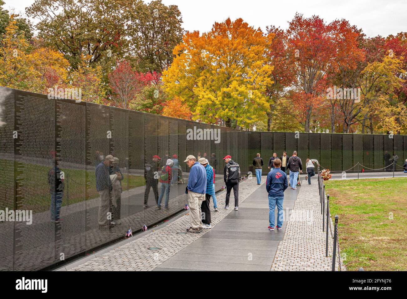 Menschen, die die Namen lesen, die auf dem Vietnam Veterans Memorial eingeschrieben sind, das die US-Streitkräfte ehrt, die im Vietnamkrieg in Washington DC gekämpft haben Stockfoto