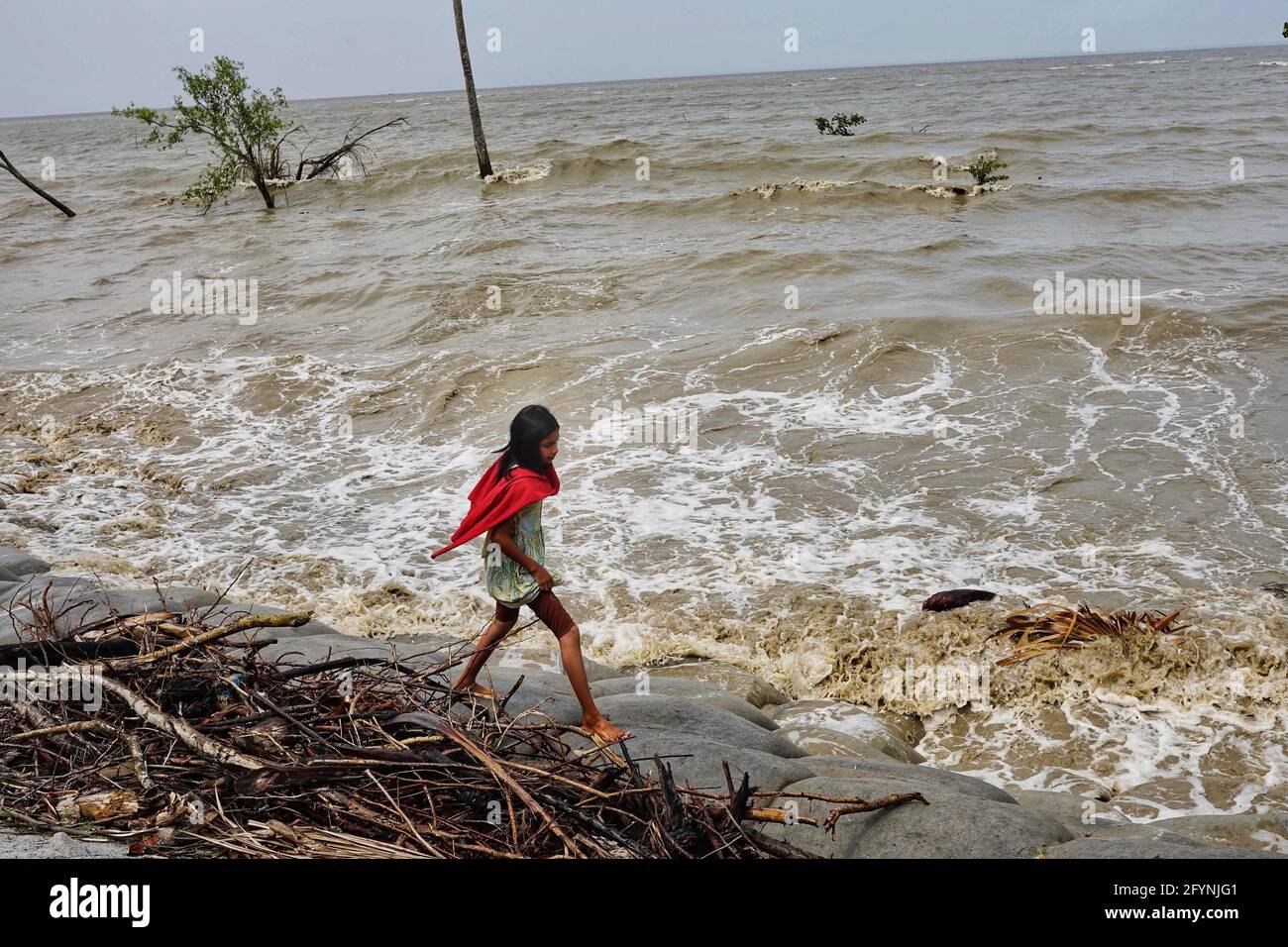 Barguna, Bangladesch. Mai 2021. Ein Kind spaziert nach dem Zyklon YaaS-Effekt im Küstengebiet Patharghata in Barguna auf dem Damm.am Mittwoch wurden mindestens zwei Todesfälle gemeldet, als der Zyklon YaaS in den Küstengebieten Bangladeschs Stürme und Überschwemmungen auslöste. Kredit: Sultan Mahmud Mukut/SOPA Images/ZUMA Wire/Alamy Live Nachrichten Stockfoto