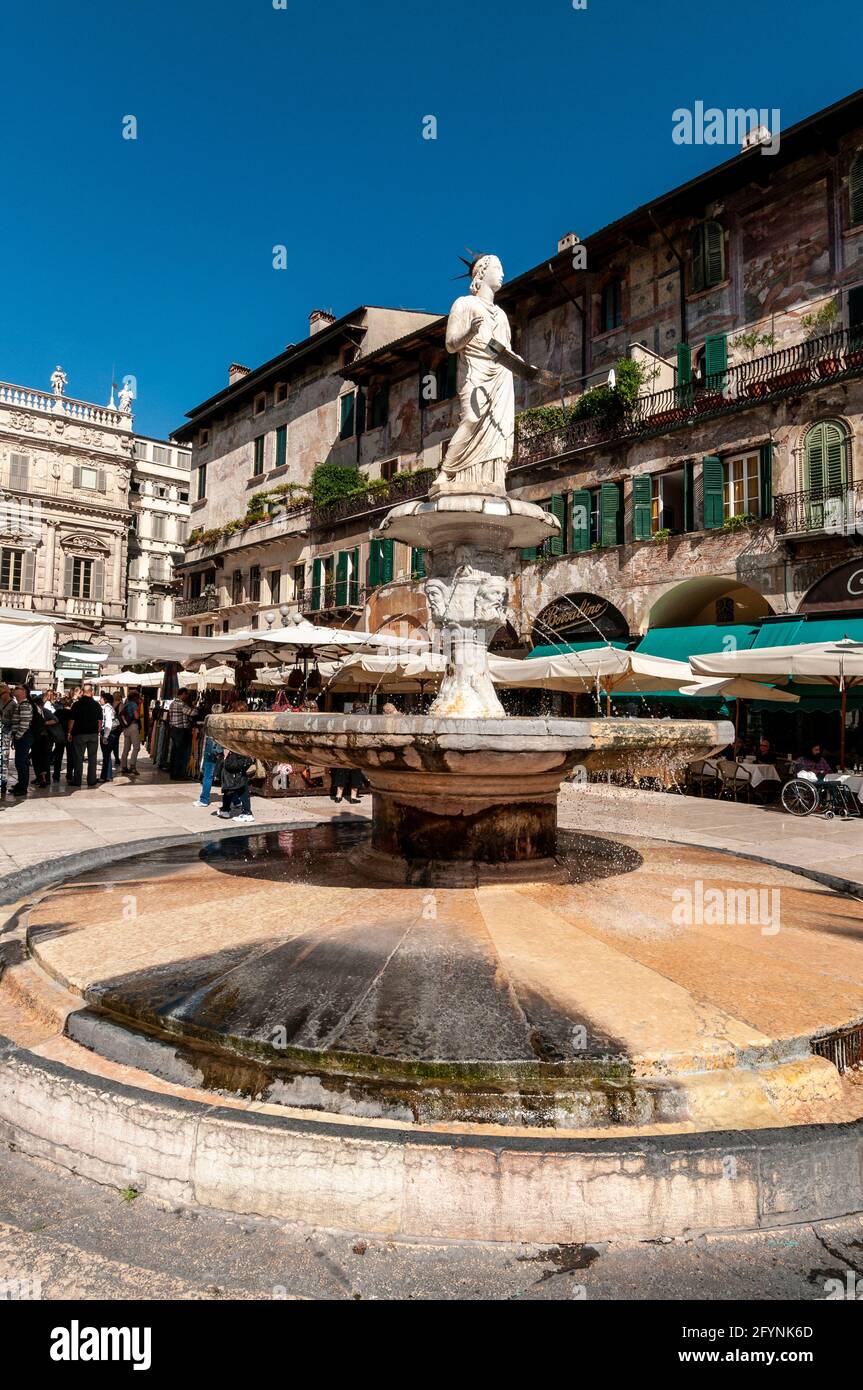 Im Zentrum von Plazza Delle Erbe ist ein Römer Skulptur einer Statue der Madonna aus dem Jahr 380 mit Ein Wasserbrunnen in der mittelalterlichen Stadt Verona Stockfoto