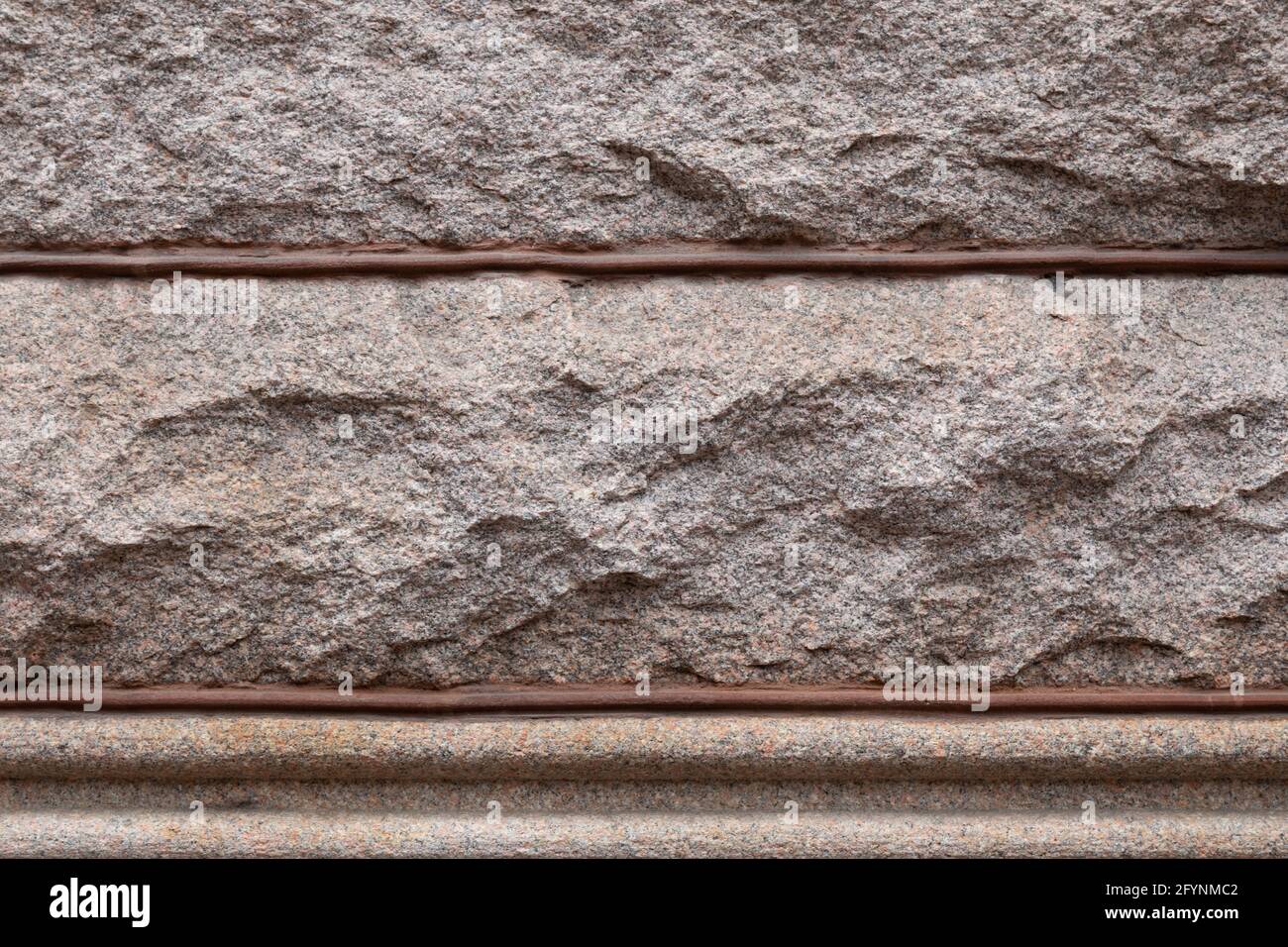 Hintergrund von rustikalen Granitblöcken durch Perlenmörtel geteilt, architektonische Details, horizontaler Aspekt Stockfoto