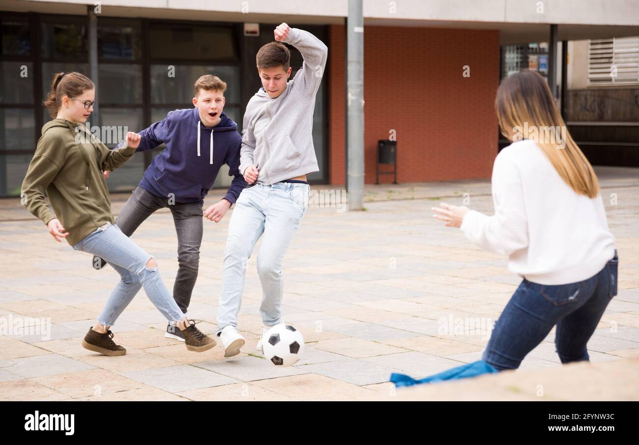 Teen Freunde verbringen Zeit zusammen im Freien spielen mit Ball auf Platz in der Nähe der Schule Stockfoto