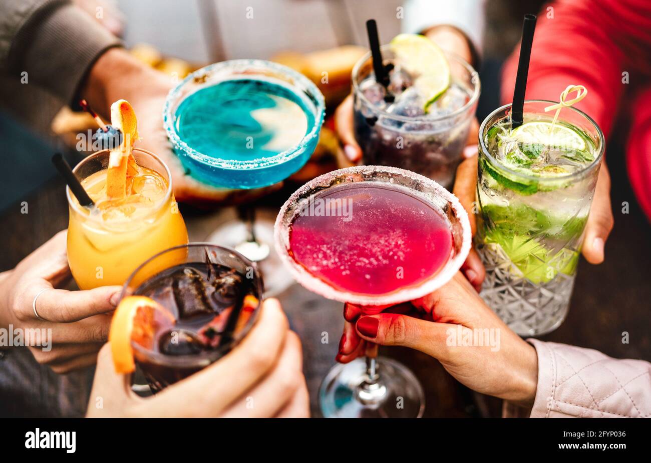 Menschen toasten bunte ausgefallene Getränke - Junge Freunde haben Spaß zusammen trinken Cocktails zur Happy Hour - Gesellschaftsparty Zeit Stockfoto