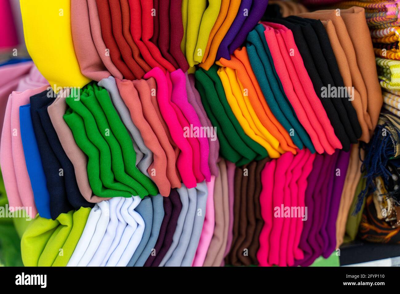 Stapel von bunten Stoffen auf dem Markt. Stockfoto