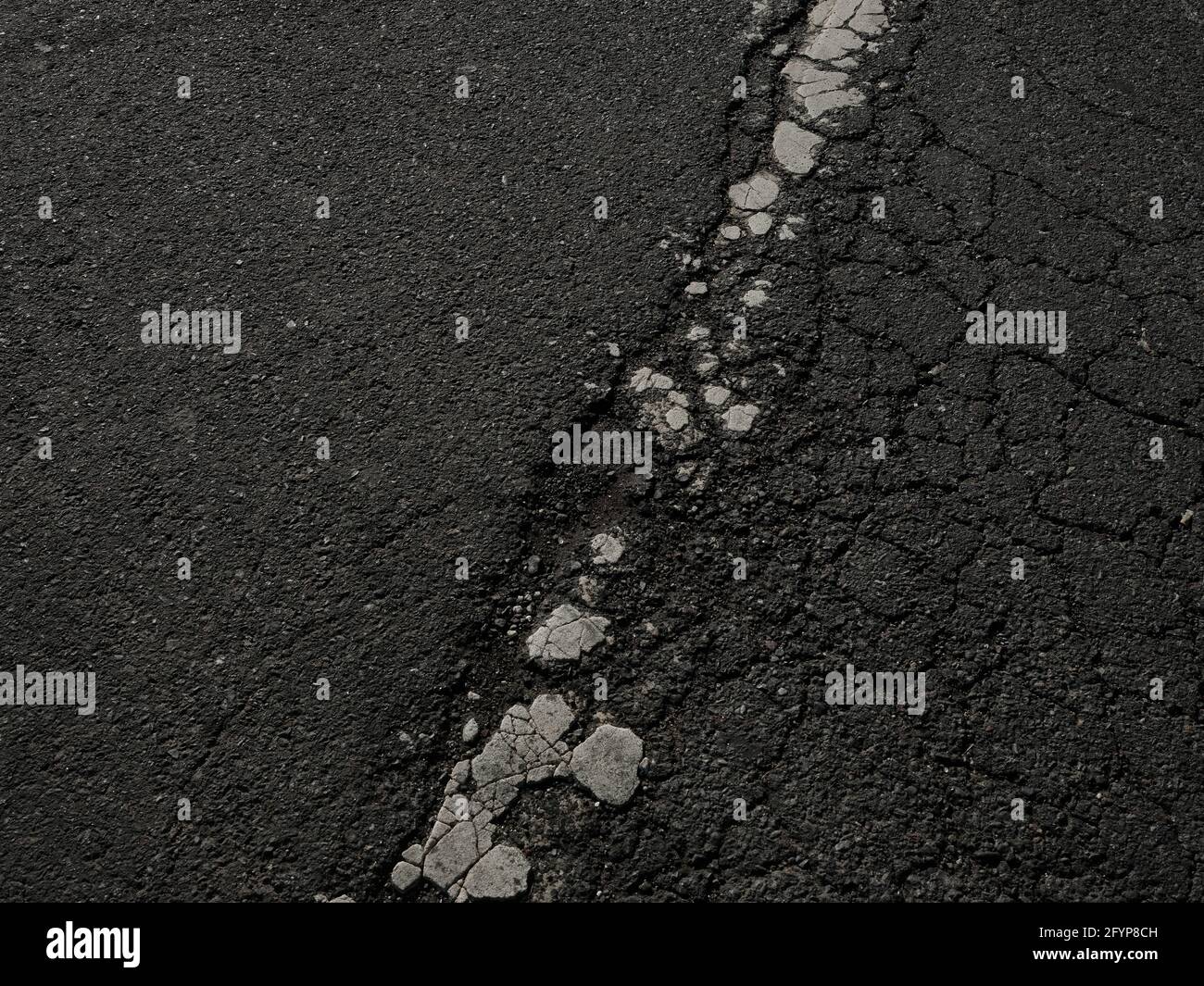 Gesprungene Asphalt-Straßenmarkierung Stockfoto