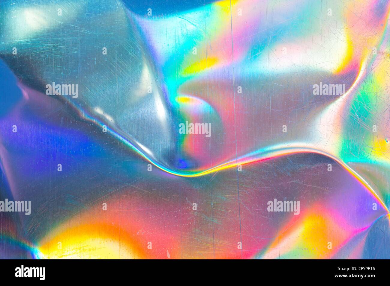 Zerkratzte, gebogene Metallstruktur im Regenbogenlicht Stockfoto