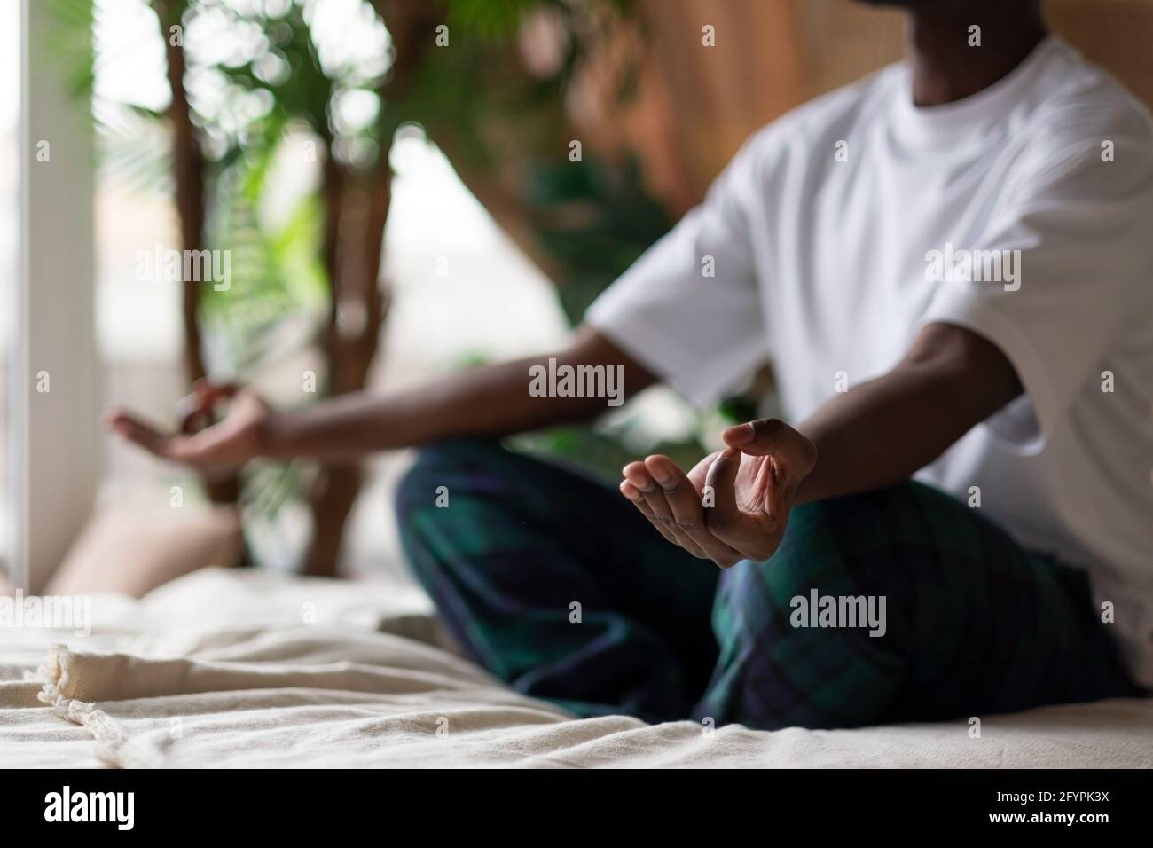 Junger afrikanischer Mann meditiert an seinem Schlafzimmer in der sitzend Morgen Stockfoto