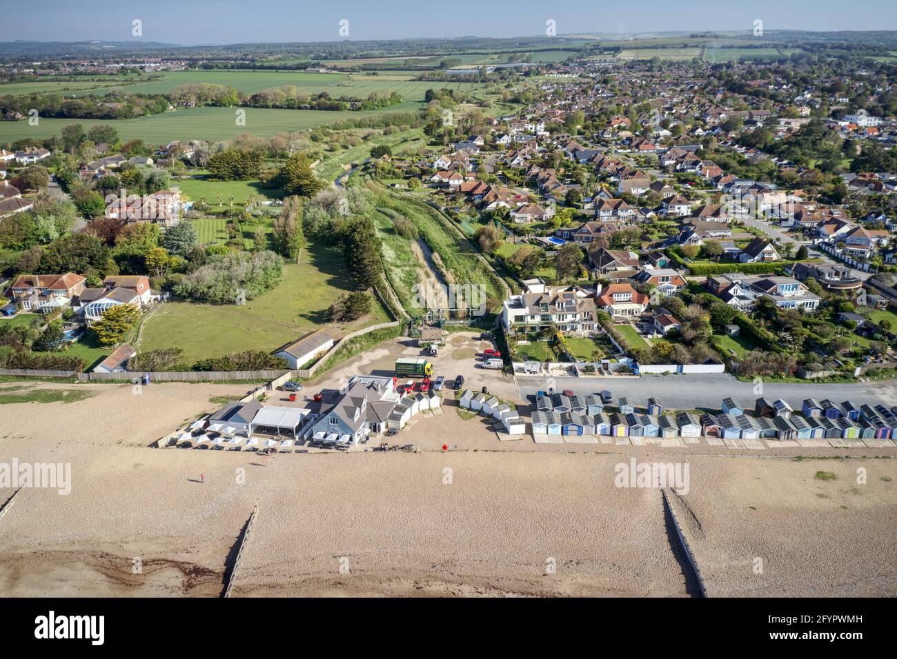 Ferring am Ärmelkanal mit der Ferring Rife, die neben dem Dorf Ferring und in Richtung der Strandhütten und der Küste verläuft. Antenne Stockfoto