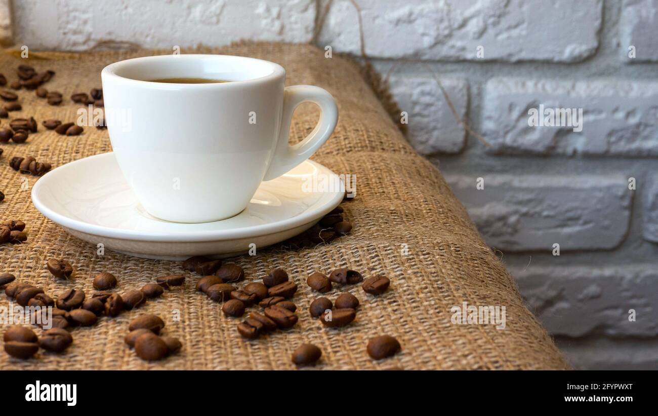 Duftender schwarzer Kaffee in einer Tasse, Kaffeebohnen mit einer Retro-Kaffeetasse. Stockfoto