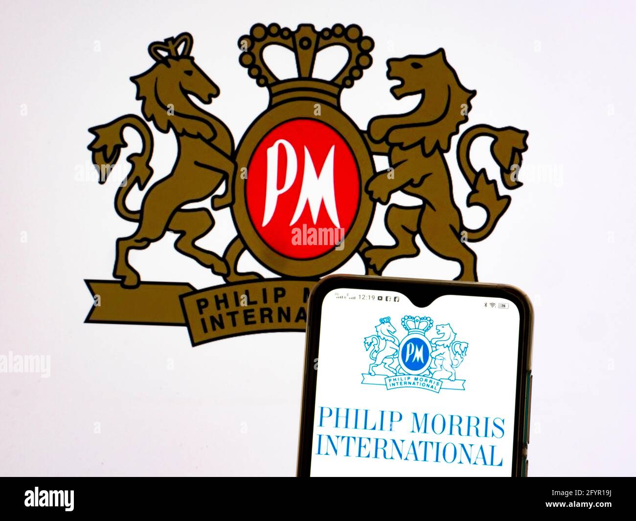 In dieser Abbildung ist ein Logo von Philip Morris International Inc. Zu sehen, das auf einem Smartphone angezeigt wird. Stockfoto