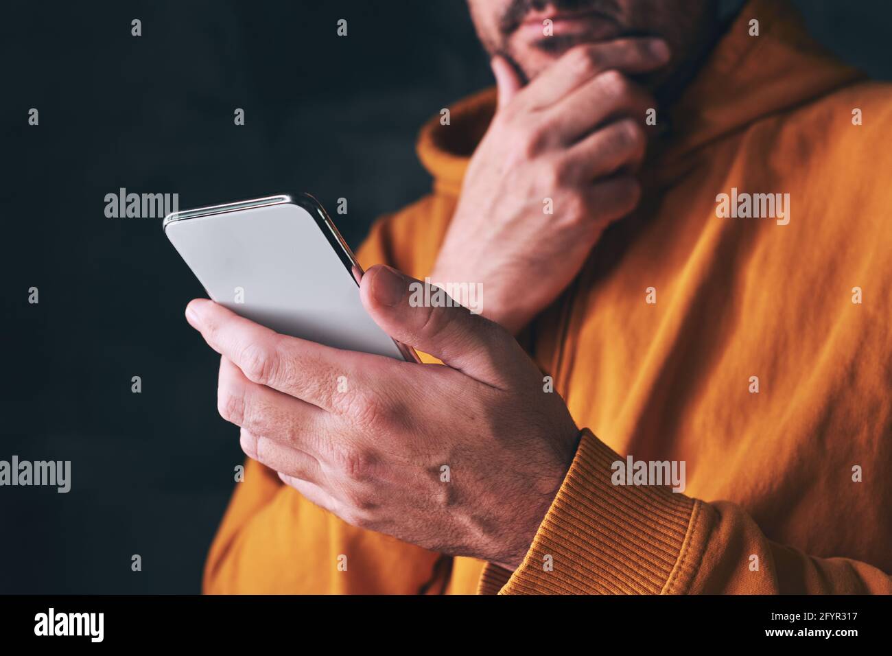 Mann mit Smartphone, liest Online-Nachrichten oder Social-Media-Status, Nahaufnahme mit selektivem Fokus Stockfoto