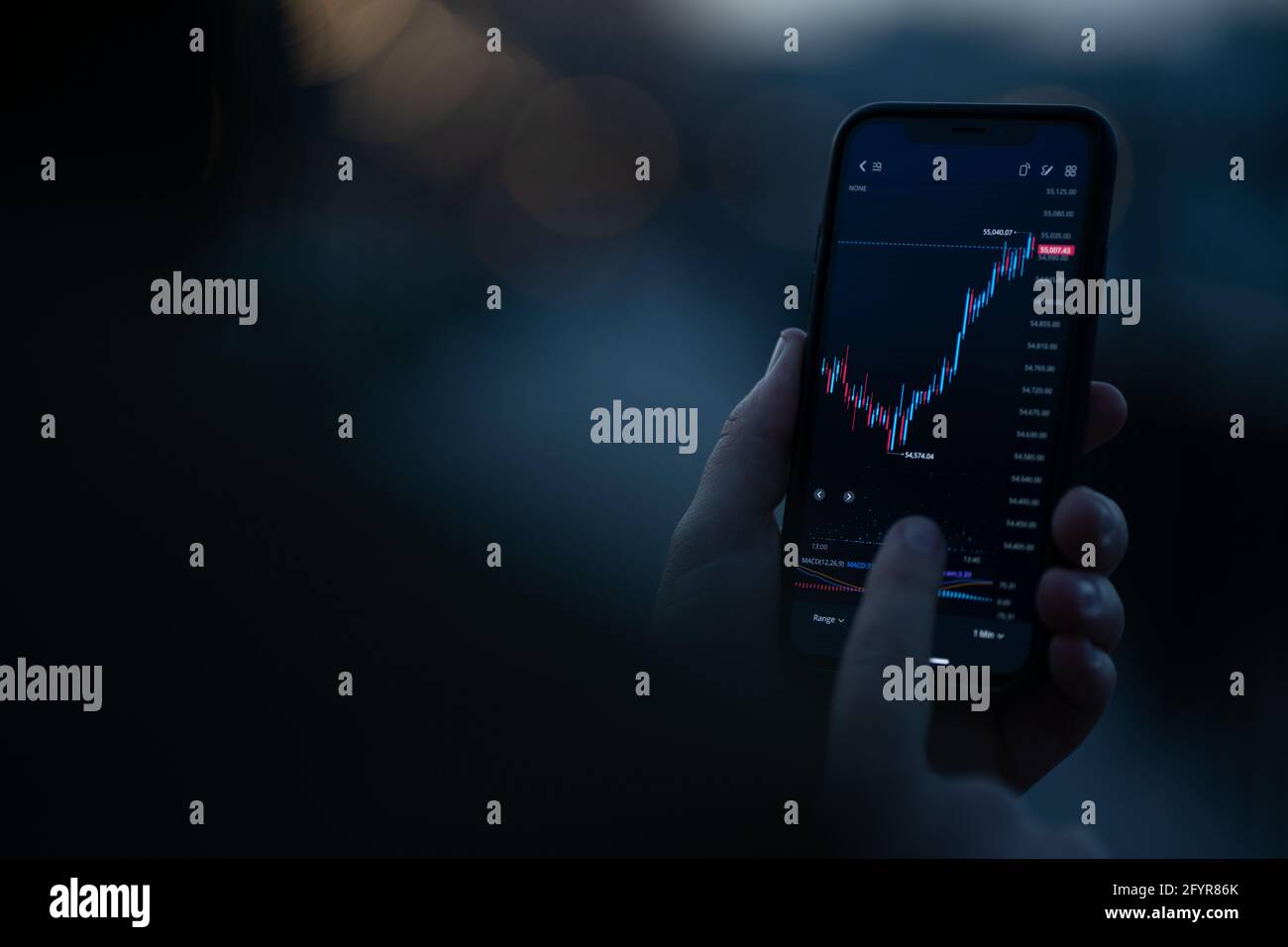 Anleger überprüfen Börsenmarktdaten in der mobilen App auf Smartphone Stockfoto