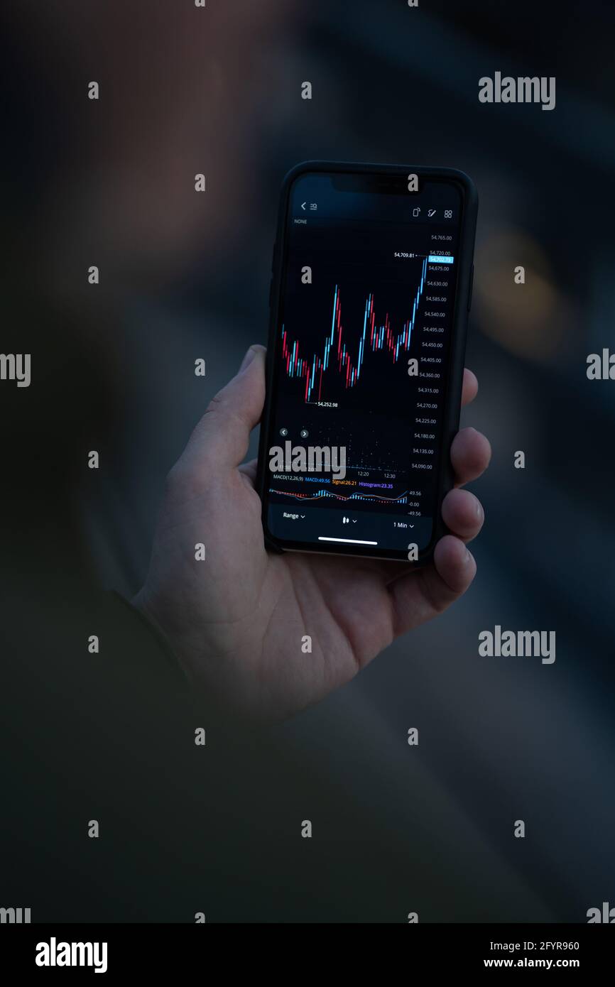 Unternehmer-Trader betrachten die Aktienmarktdaten auf dem Smartphone-Bildschirm Und Forex-Diagramm analysieren Stockfoto
