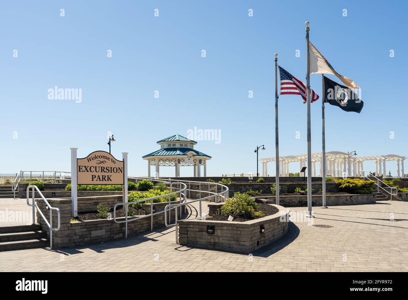 Sea Isle City, NJ - 13. Mai 2021: Willkommen zum Exkursion Park Schild an der Promenade mit Fahnen und dem Pavillon. Sowie eine Rampe für Behinderte. Stockfoto