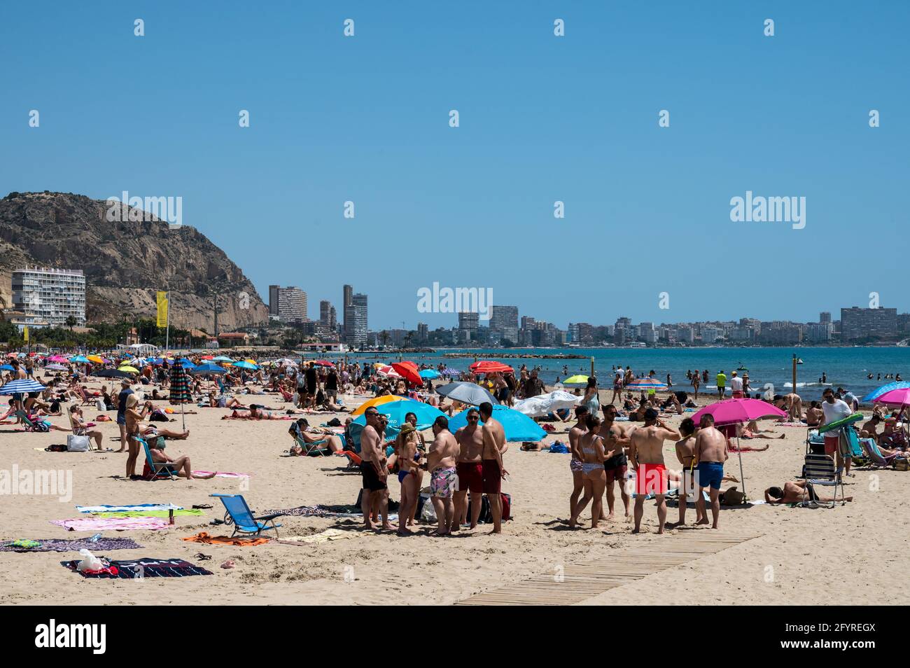 Alicante, Spanien. Mai 2021. Die Menschen genießen hohe Temperaturen in einem überfüllten El Postiguet Strand von Alicante. Die valencianische Gemeinschaft hat am Montag neue Beschränkungsmaßnahmen gegen das Coronavirus (Covid-19) veröffentlicht, unter anderem gegen das Coronavirus, An den Stränden ist es nicht mehr notwendig, in den Ruhezeiten vor oder nach dem Baden eine Maske zu tragen und dabei den Mindestabstand von 1.5 Metern zu anderen Menschen, die nicht zusammen leben, mit einer maximalen Gruppe von 10 Personen einzuhalten. Quelle: Marcos del Mazo/Alamy Live News Stockfoto