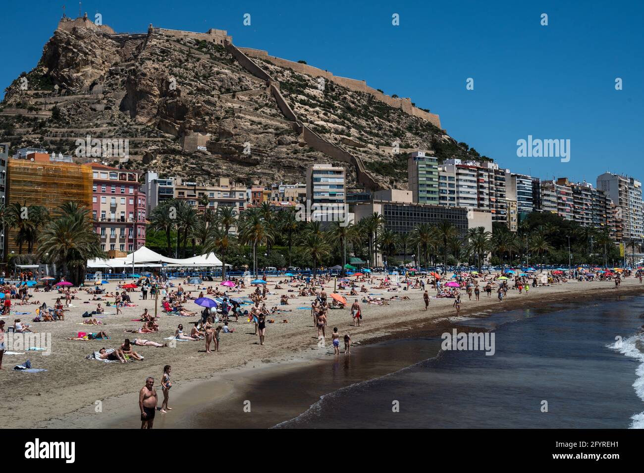 Alicante, Spanien. Mai 2021. Die Menschen genießen hohe Temperaturen in einem überfüllten El Postiguet Strand von Alicante. Die valencianische Gemeinschaft hat am Montag neue Beschränkungsmaßnahmen gegen das Coronavirus (Covid-19) veröffentlicht, unter anderem gegen das Coronavirus, An den Stränden ist es nicht mehr notwendig, in den Ruhezeiten vor oder nach dem Baden eine Maske zu tragen und dabei den Mindestabstand von 1.5 Metern zu anderen Menschen, die nicht zusammen leben, mit einer maximalen Gruppe von 10 Personen einzuhalten. Quelle: Marcos del Mazo/Alamy Live News Stockfoto