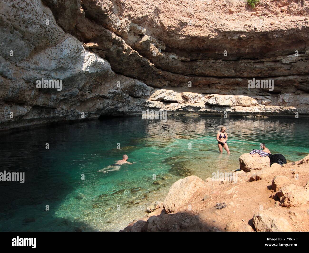 Eine Frau in einem Bikini-Badeanzug und andere Badegäste an einem sonnigen  Tag im berühmten Bimmah-Loch. Im Oman Stockfotografie - Alamy