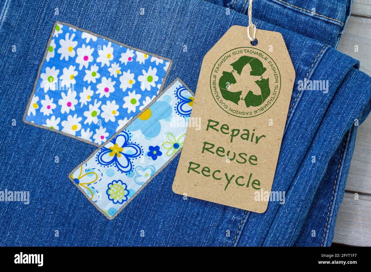 Nachhaltiges Modelabel auf reparierten Jeans, nachhaltige Mode sichtbare Ausbesserung Konzept, Reparatur, Wiederverwendung, Recycling, Kleidung und Textilien Abfälle zu reduzieren Stockfoto
