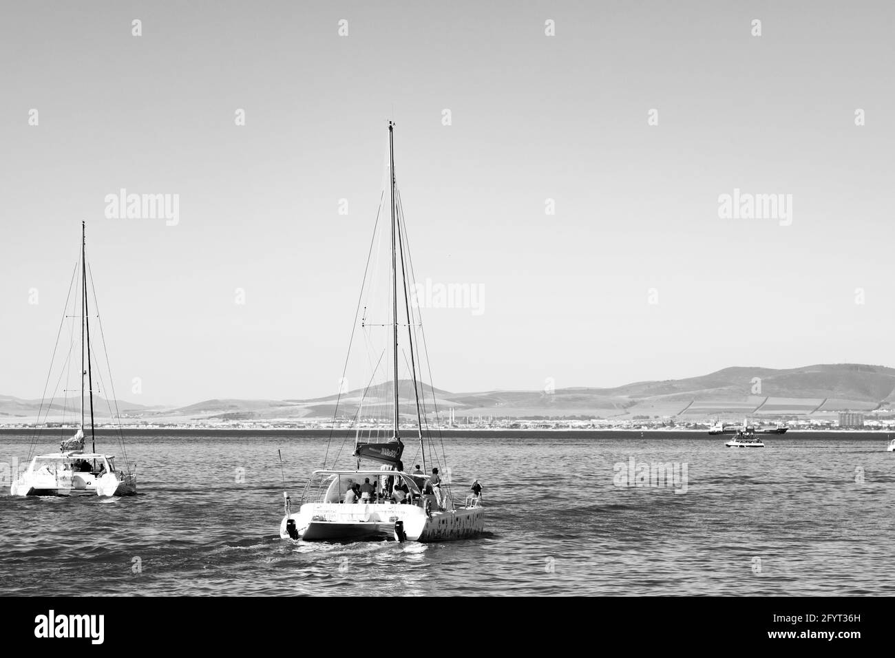 KAPSTADT, SÜDAFRIKA - 06. Jan 2021: Kapstadt, Südafrika - 13. Oktober 2019: Touristen, die auf einer Katamaran-Yacht vor dem Hafen von Cape Tow fahren Stockfoto