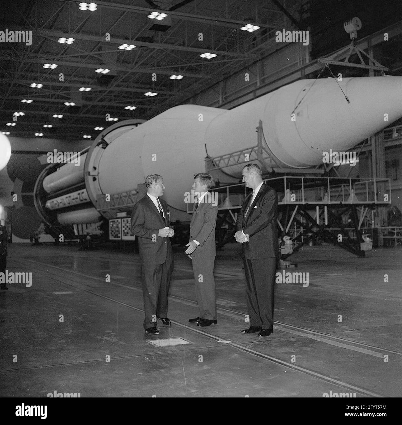 11. September 1962 Inspektionstour der NASA-Installationen: Huntsville Alabama, Redstone Army Airfield und George C. Marshall Space Flight Center, Präsident John F. Kennedy, spricht mit dem Direktor des George C. Marshall Space Flight Center (MSFC), Dr. Wernher von Braun (Mitte links), während einer Tour des MSFC im Redstone Arsenal, Huntsville, Alabama; Vice President Lyndon B. Johnson steht rechts. Die Saturn C-1 Rakete sitzt im Hintergrund. Präsident Kennedy besuchte die MSFC im Rahmen einer zweitägigen Inspektionsreise durch die Feldinstallationen der National Aeronautics and Space Administration (NASA). Stockfoto