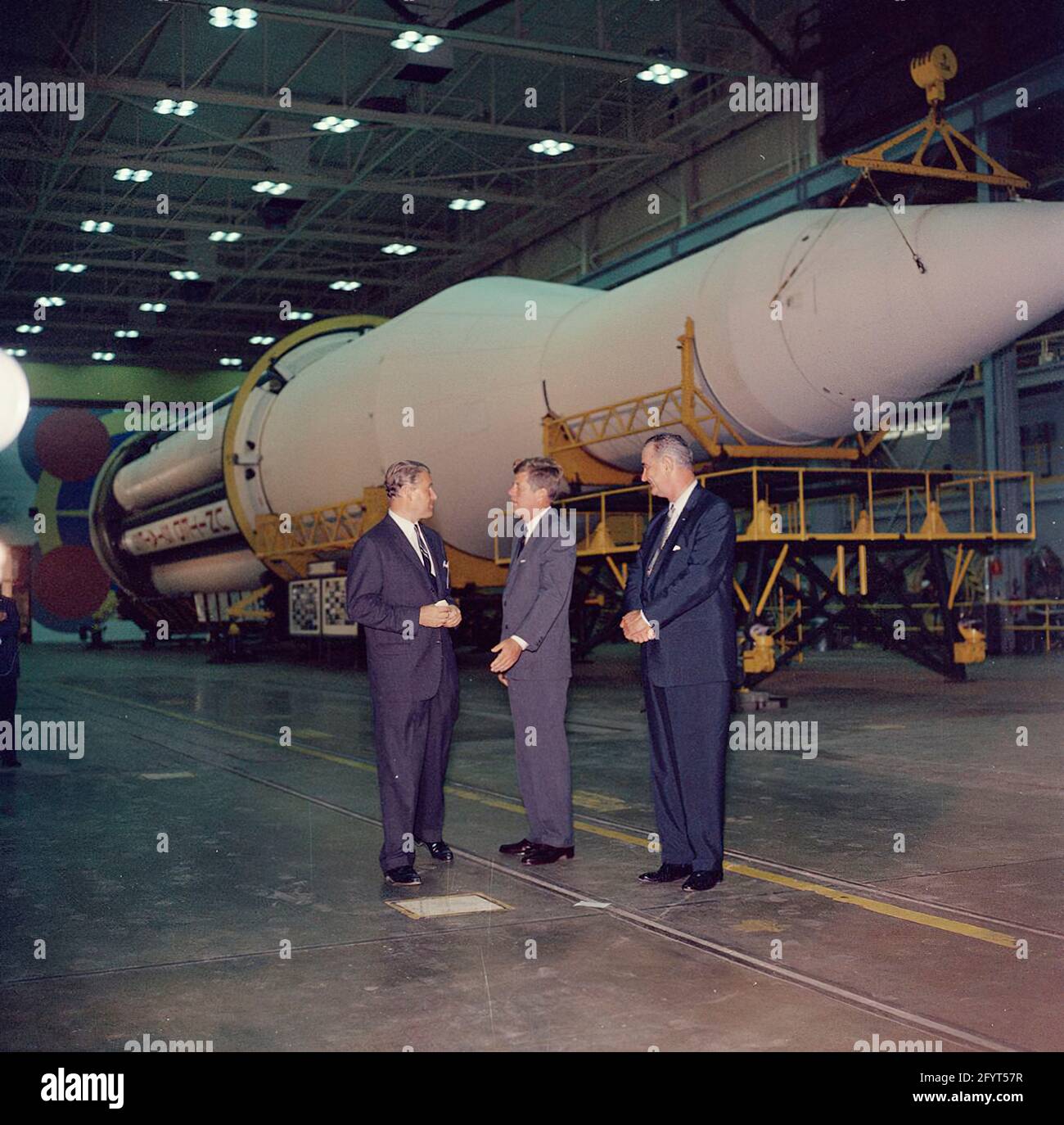 11. September 1962 Inspektionstour der NASA-Installationen: Huntsville Alabama, Redstone Army Airfield und George C. Marshall Space Flight Center, Präsident John F. Kennedy, spricht mit dem Direktor des George C. Marshall Space Flight Center (MSFC), Dr. Wernher von Braun (Mitte links), während einer Tour des MSFC im Redstone Arsenal, Huntsville, Alabama; Vice President Lyndon B. Johnson steht rechts. Die Saturn C-1 Rakete sitzt im Hintergrund. Präsident Kennedy besuchte die MSFC im Rahmen einer zweitägigen Inspektionsreise durch die Feldinstallationen der National Aeronautics and Space Administration (NASA). Stockfoto