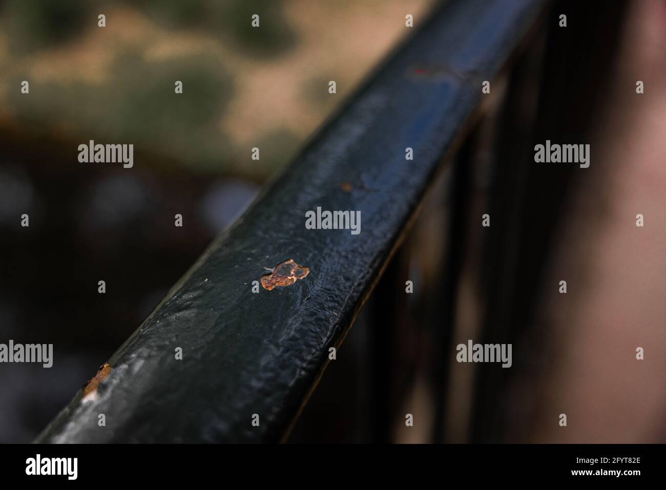 Die leicht beschädigte Oberfläche eines schwarzen Handlaufs Stockfoto