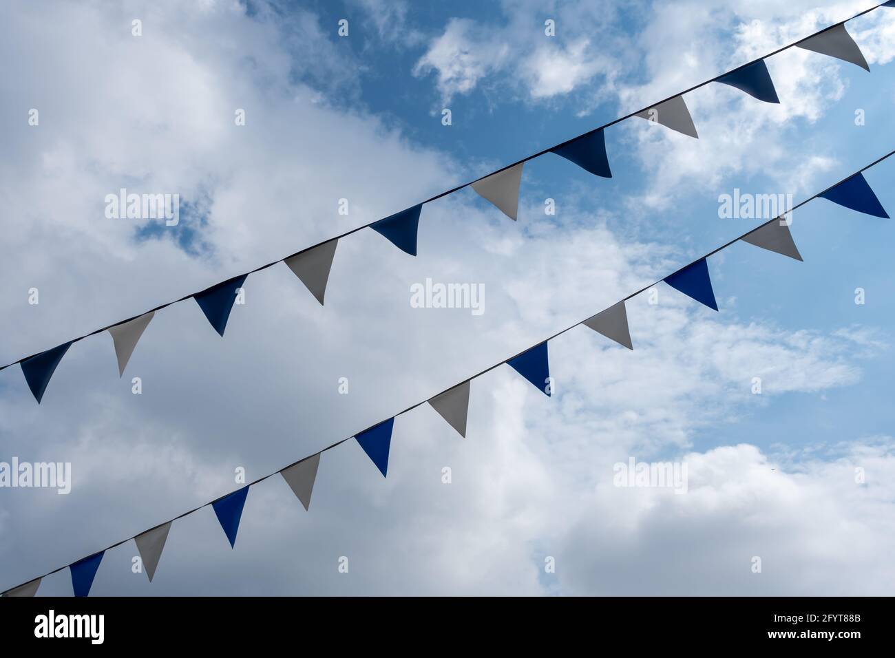 Dreiecksflaggen hängen vor dem Hintergrund des bewölkten Himmels Stockfoto