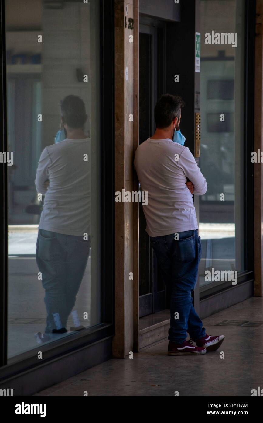 Arezzo, Italien, 28. Mai 2021, ein junger Mann, der vor einem Geschäft steht Stockfoto