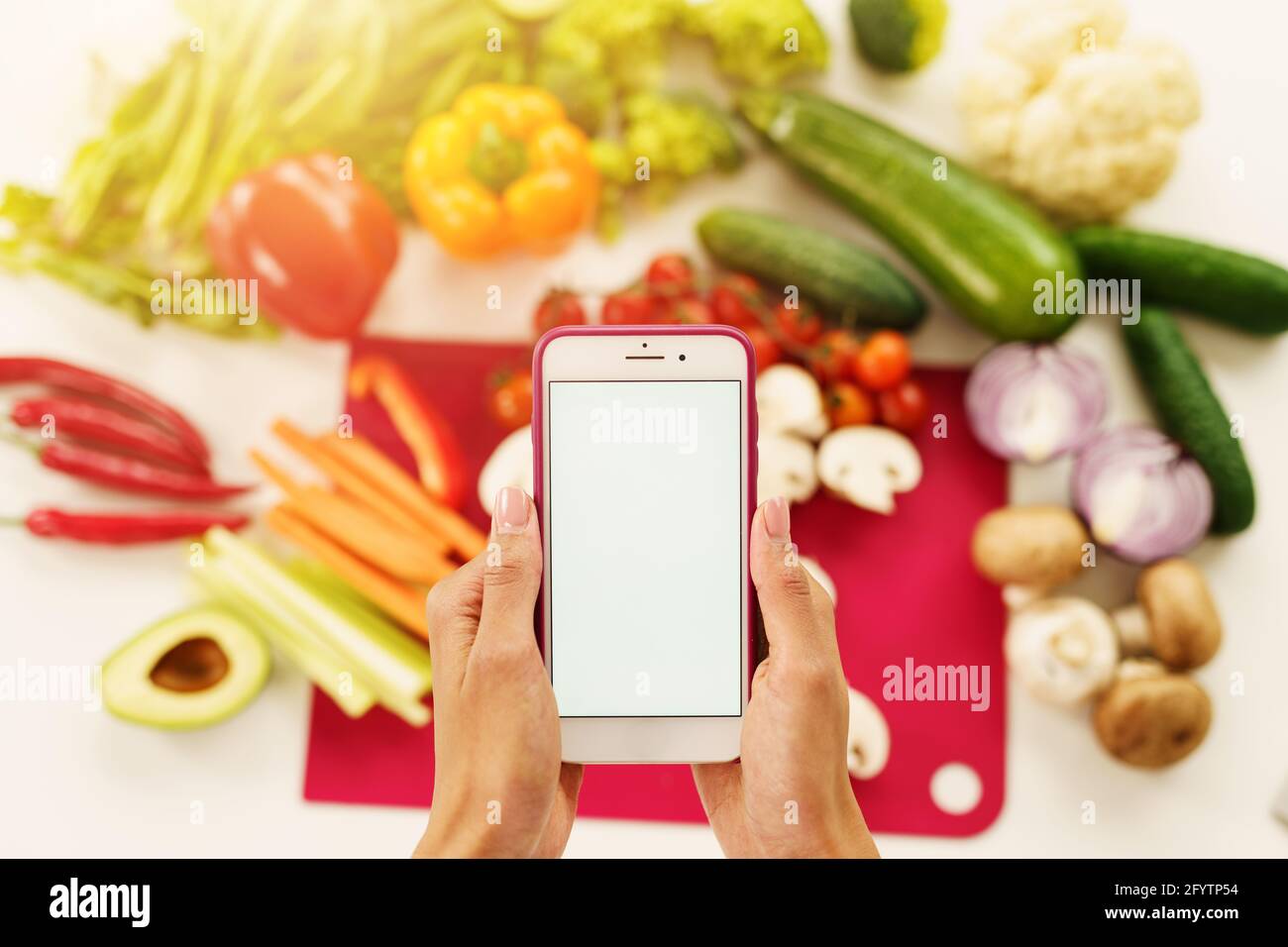 Cook folgt einem Rezept aus Gemüse vom Smartphone Stockfoto