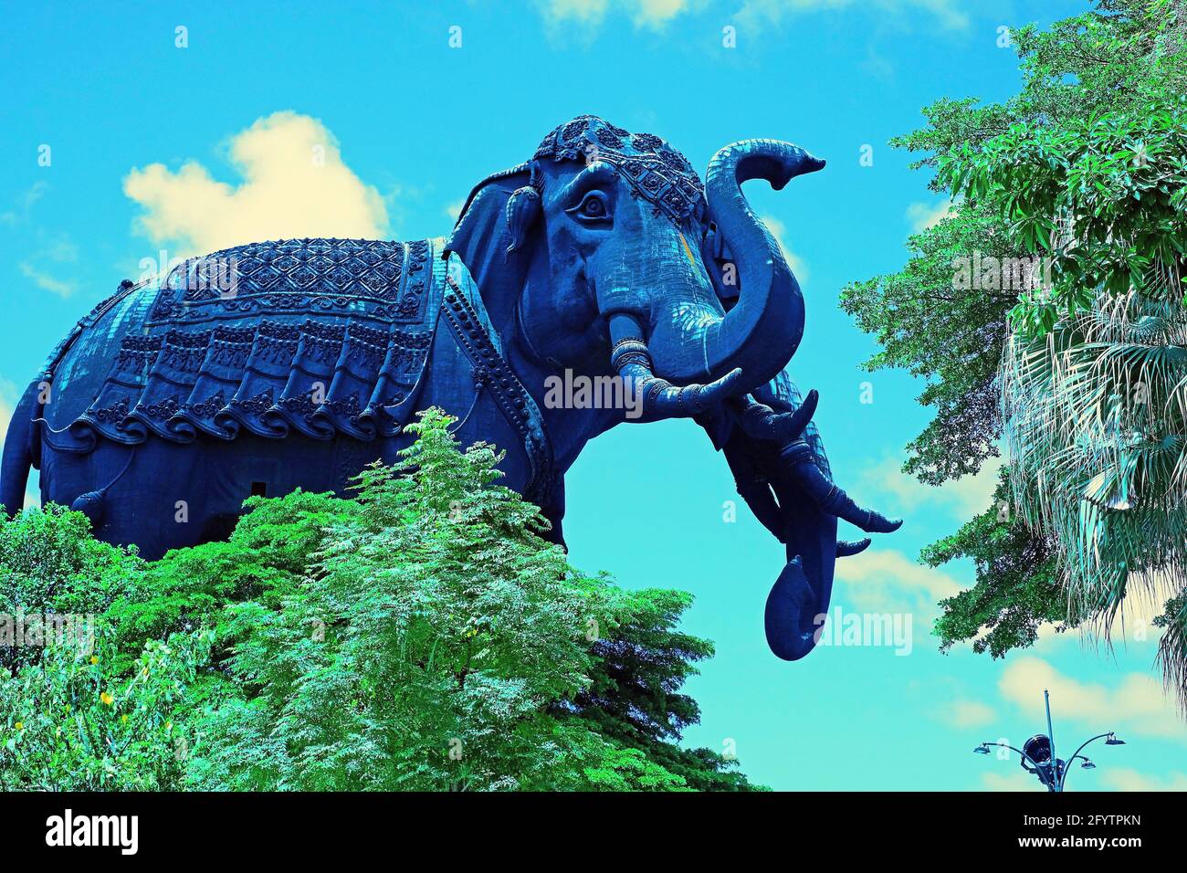 Die Supergigant Elephant Sculpture steht hinter den Bäumen Auf blauem Hintergrund 1 Stockfoto