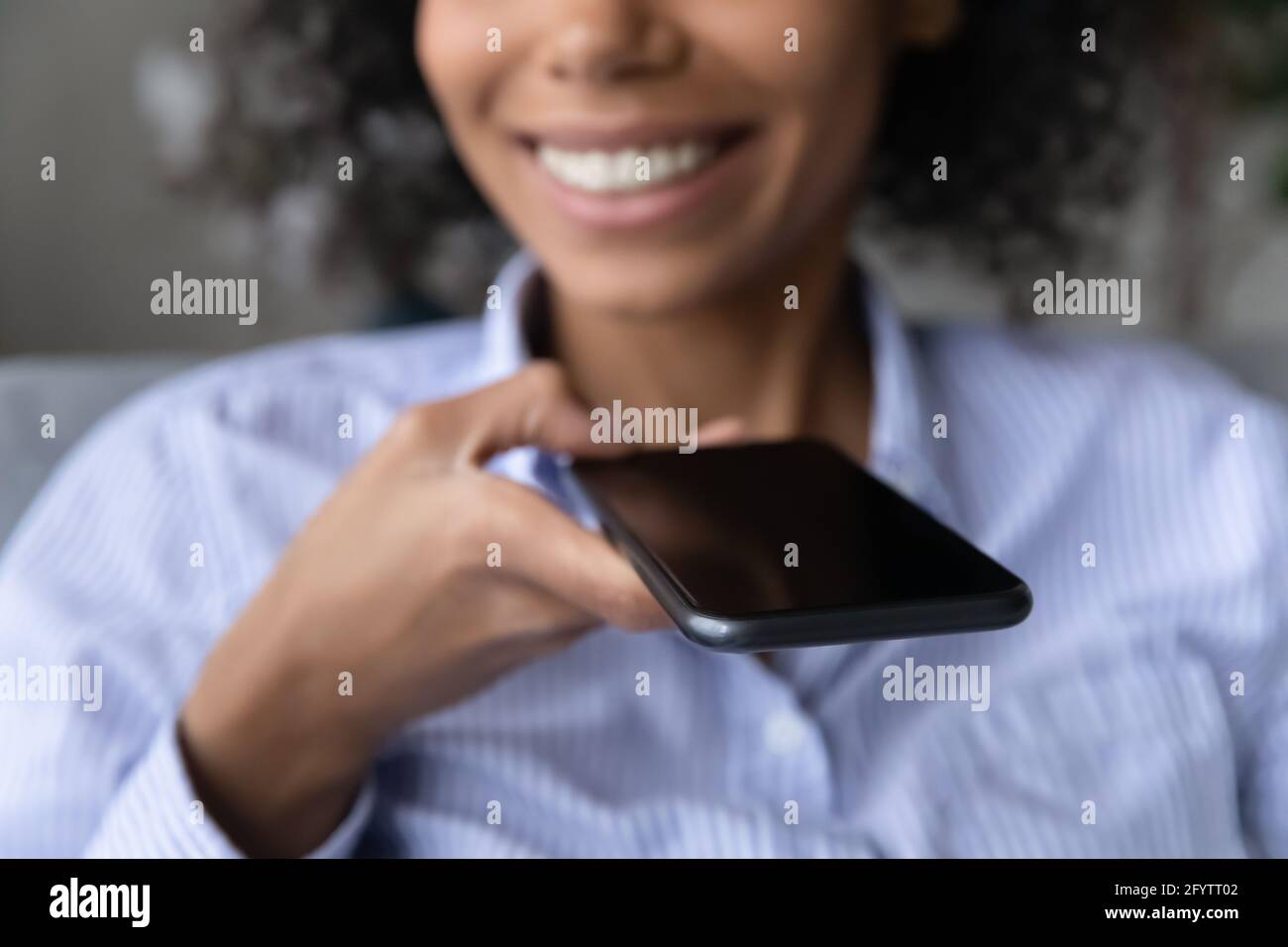 Nahaufnahme einer Birazialfrau, die über Lautsprecher auf dem Mobiltelefon spricht Stockfoto