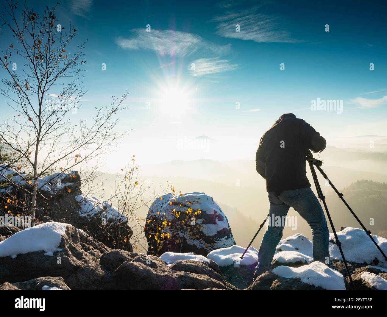Naturfotograf, der in den verschneiten Bergen fotografiert. Toller Wintermorgen Stockfoto