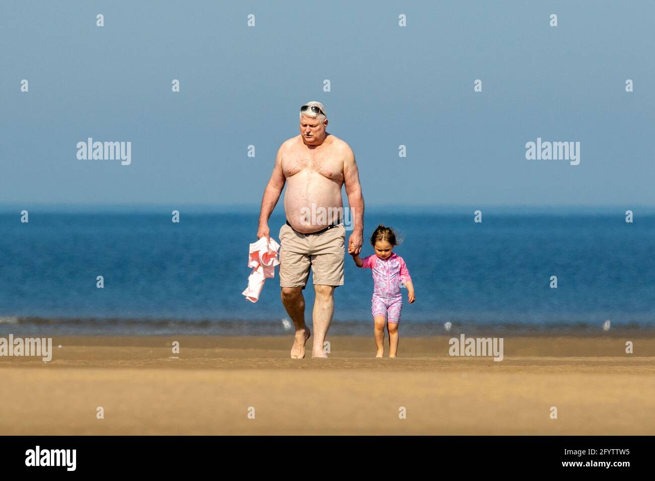 Vater und Tochter am Strand von Southport, Merseyside, 30. Mai 2021. Die Menschen am Meer in Southport genießen an einem wunderschönen Feiertagswochenende einen Tag mit schönem, warmen Sonnenschein und klarem, blauen Himmel. Quelle: Cernan Elias/Alamy Live News Stockfoto