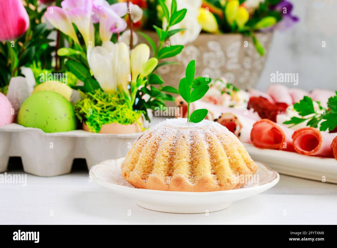 Festliche Ostertafel mit traditionellen Kuchen- und Blumendekorationen. Partydekor Stockfoto