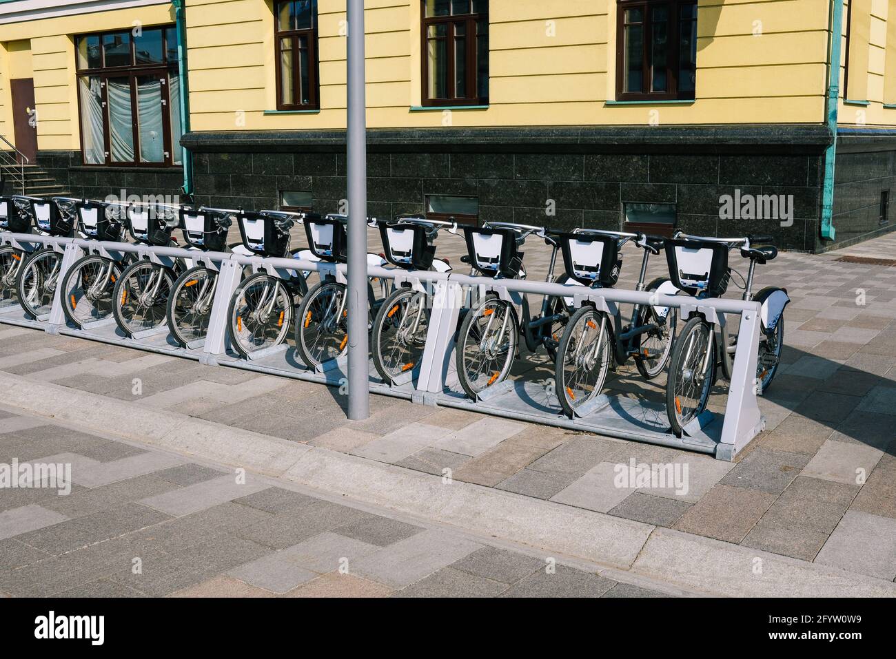 Fahrräder können gemietet werden. Fahrräder zur Miete sind in einer Reihe in der Nähe des Gebäudes geparkt. Stadtfahrräder Stockfoto