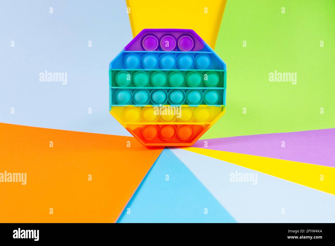Antistress-Pop-it-Spielzeug. Rainbow Silikon sensorische Fidget auf farbivollem Hintergrund. Neue beliebte trendige Silikon-Spielzeug. Stockfoto