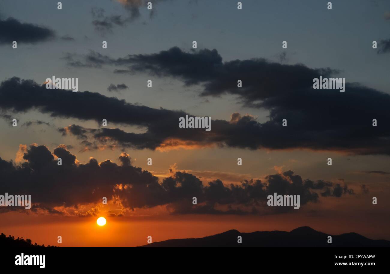 Hochauflösende Aufnahme der Sonne mit Wolken während des Sonnenuntergangs der hügeligen Gegend von Himachal Pradesh Stockfoto