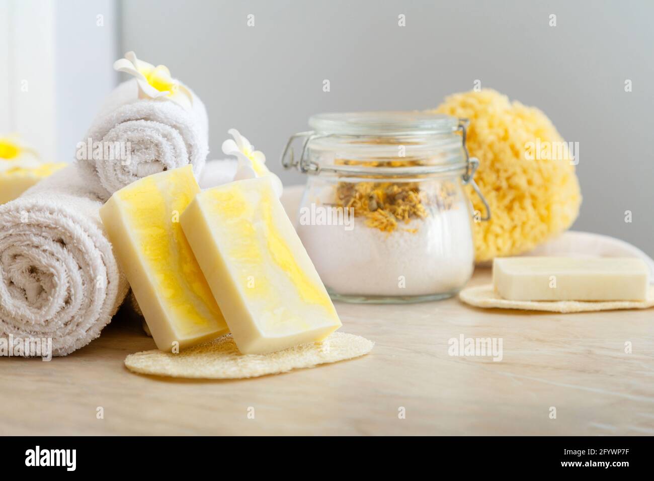 Handgemachte Seife, Spa-Bad Produkte Aroma Salz, weiße Handtücher tropischen Blumen Zusammensetzung auf Marmortisch. Startseite Beauty-Kosmetik-Produkte für Entspannung Stockfoto