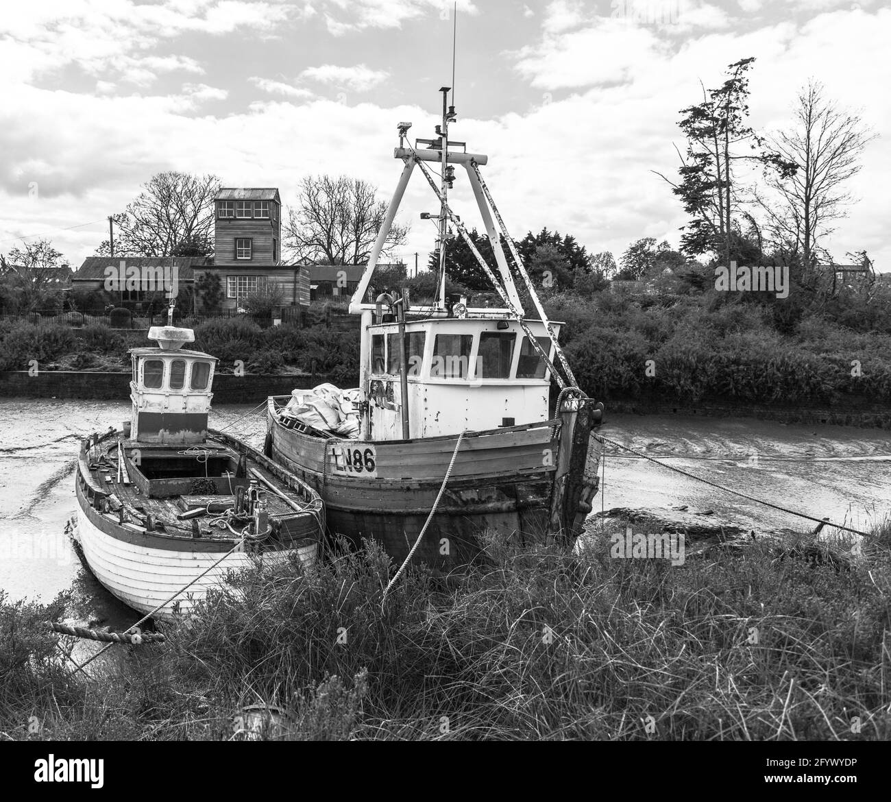 Festgemacht Fischerboote in Brancaster Staith in North Norfolk, einfarbig gesehen. Stockfoto