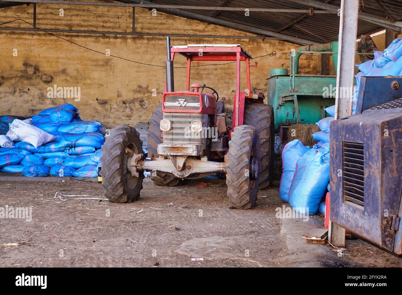 Ein roter Traktor, der in einer Garage steht Stockfoto