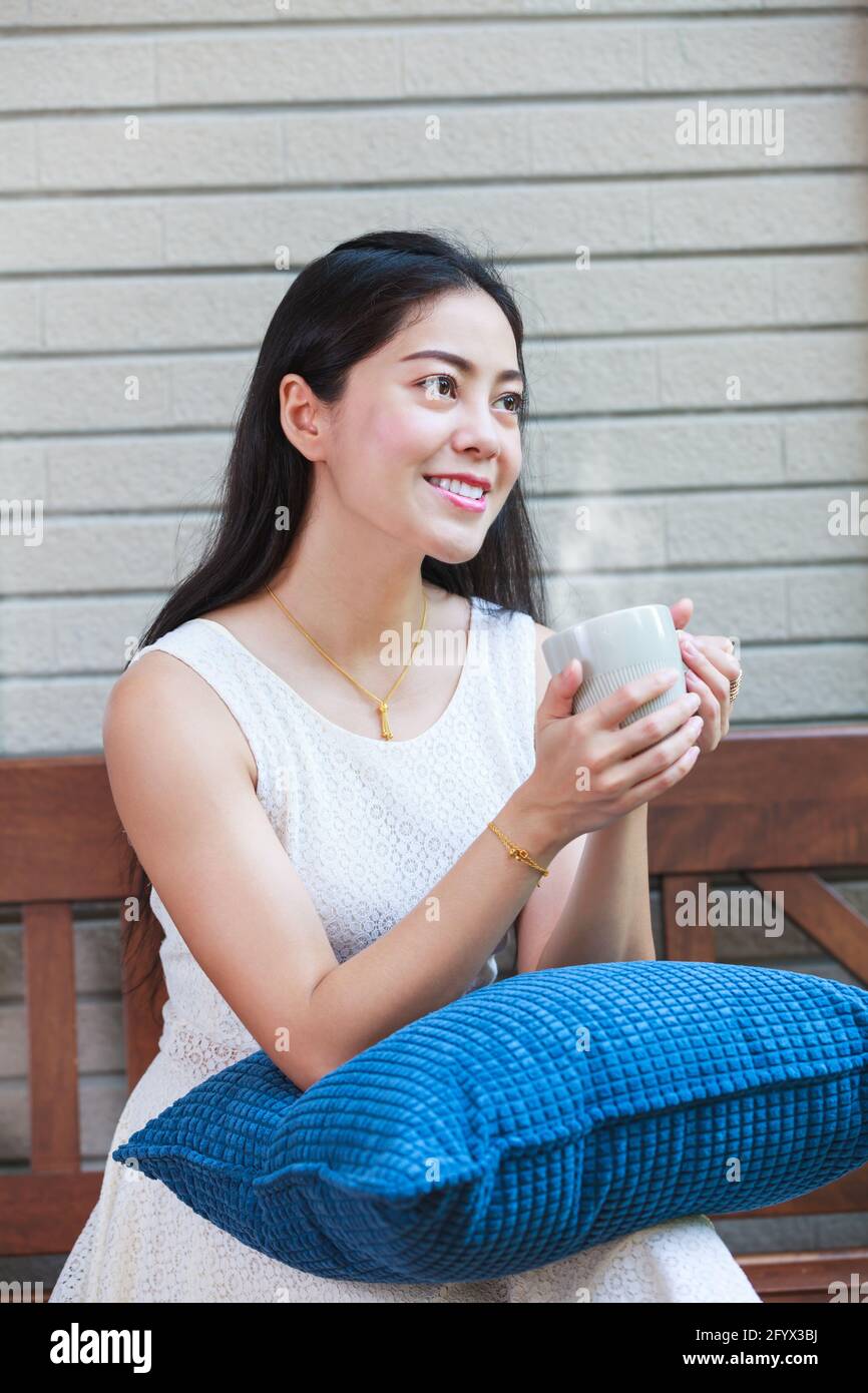 Lifestyle der schönen asiatischen Frau genießt frischen Kaffee am Morgen zu Hause. Glückliche Zeit des Stadtlebens. Stockfoto