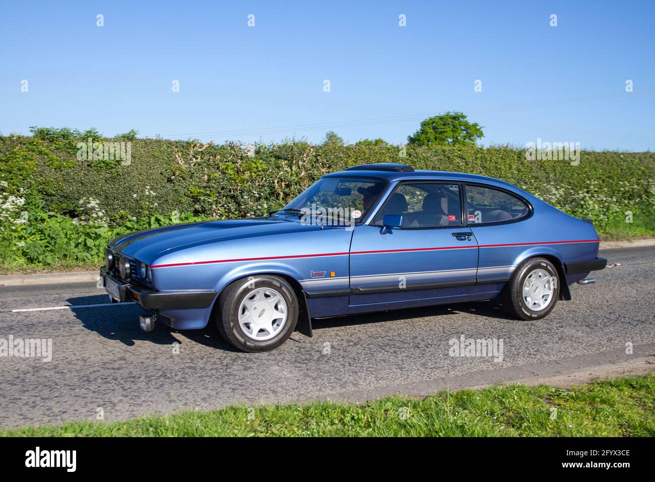 Blaues Ford Capri Laser Fastback Coupé aus den 1987 80er Jahren, 2000 ccm Benzinfließheck auf dem Weg zur Capesthorne Hall Oldtimer-Veranstaltung in Cheshire, Großbritannien Stockfoto