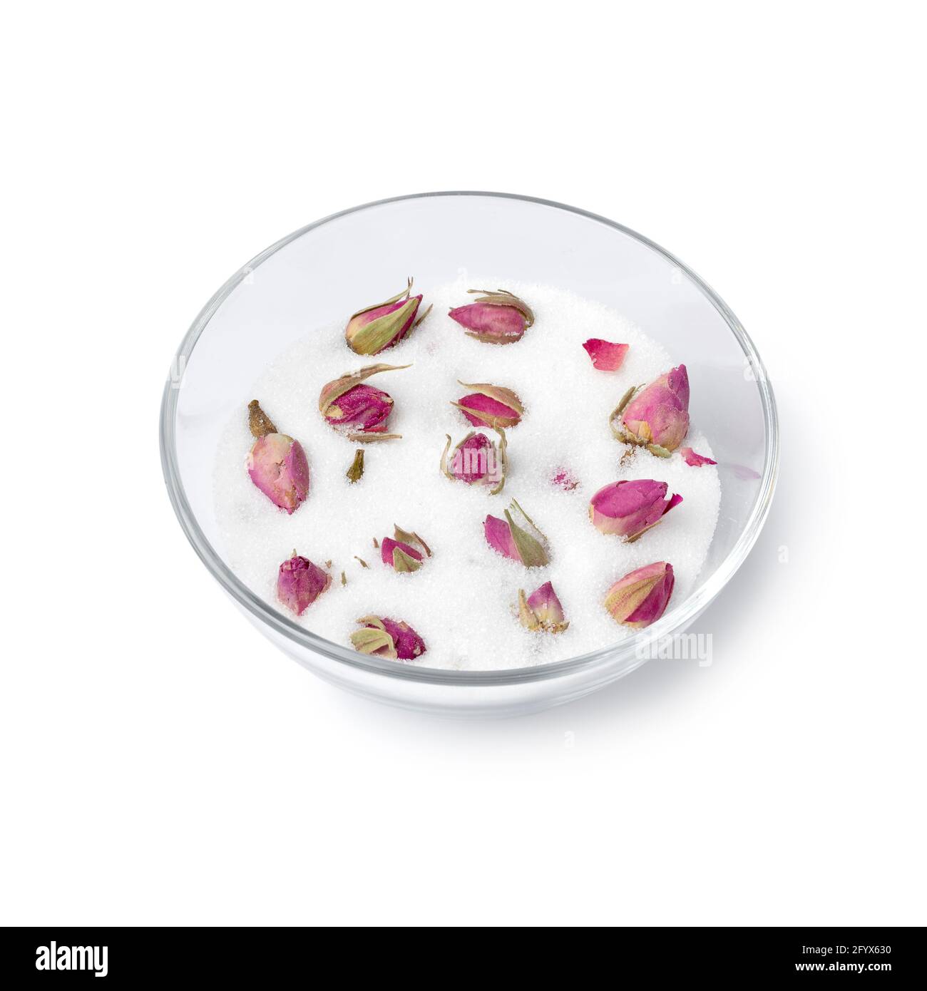 Getrocknete Rosenknospen in einer Glasschale mit weißem Zucker Um den Rosengeschmack und Geruch isoliert auf Weiß zu erhalten Hintergrund Stockfoto