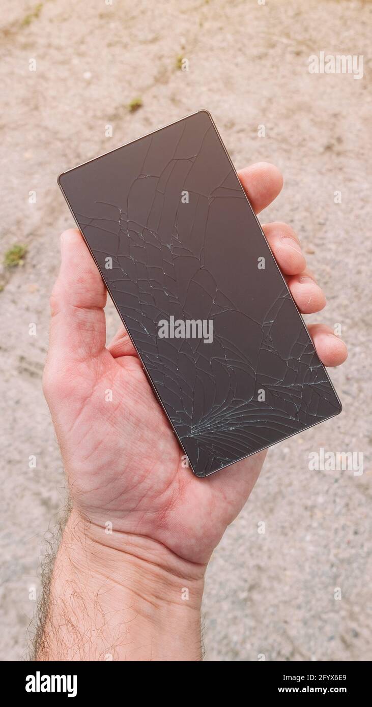 Mann, der ein defektes Smartphone in der Hand hält, Nahaufnahme mit selektivem Fokus Stockfoto Mann, der ein defektes Smartphone in der Hand hält, Nahaufnahme mit selektivem Fokus Stockfoto