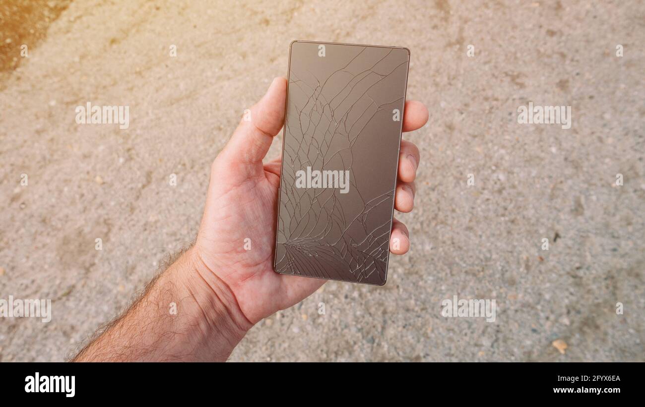 Mann, der ein defektes Smartphone in der Hand hält, Nahaufnahme mit selektivem Fokus Stockfoto Mann, der ein defektes Smartphone in der Hand hält, Nahaufnahme mit selektivem Fokus Stockfoto