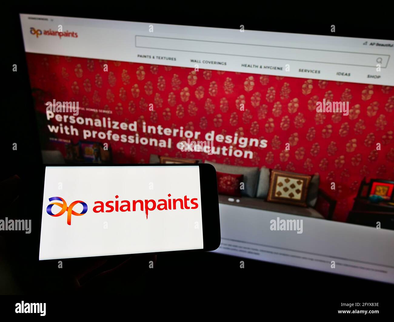 Person, die Mobiltelefon mit Logo des indischen Farbherstellers Asian Paints Ltd. Auf dem Bildschirm vor der Website des Unternehmens hält. Konzentrieren Sie sich auf die Telefonanzeige. Stockfoto