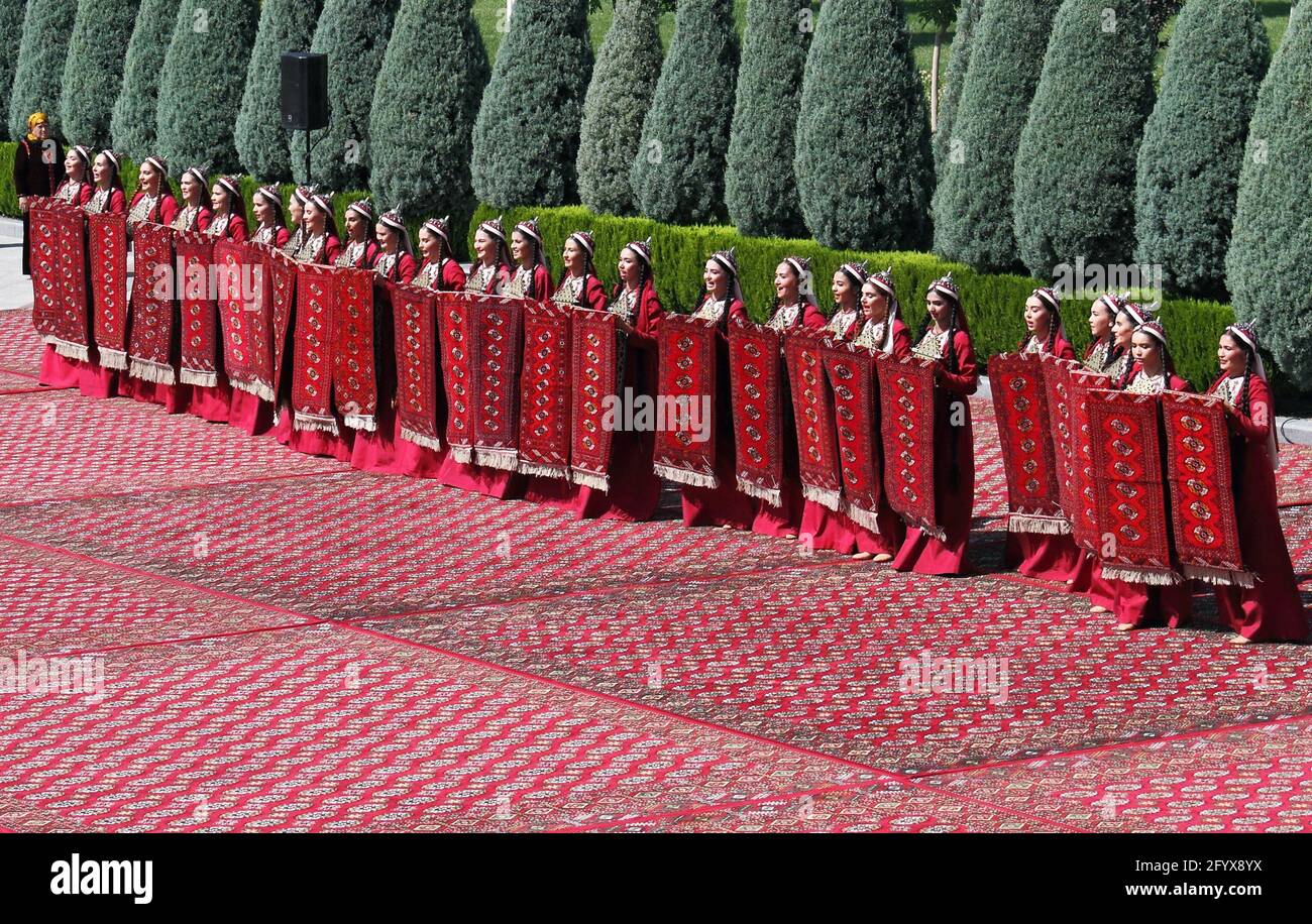 Frauen, die in traditioneller Kleidung gekleidet sind, treten während der Feierlichkeiten zum nationalen turkmenischen Teppichtag in Aschgabat, Turkmenistan, am 30. Mai 2021 auf. REUTERS/Vyacheslav Sarkisyan Stockfoto